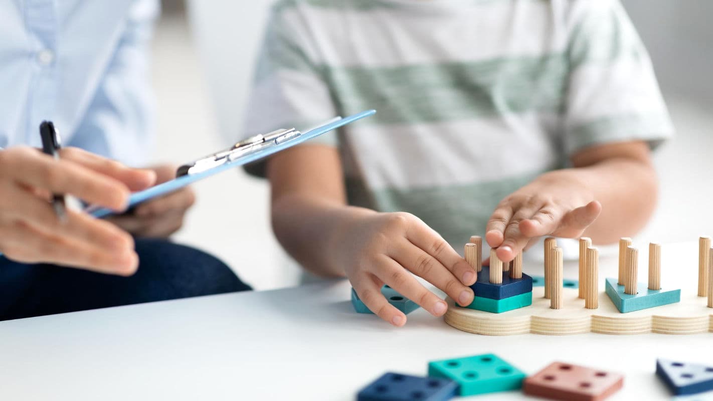 ATHERA Ergotherapeutin trainiert Feinmotorik mit Patienten mithilfe eines Steckbretts