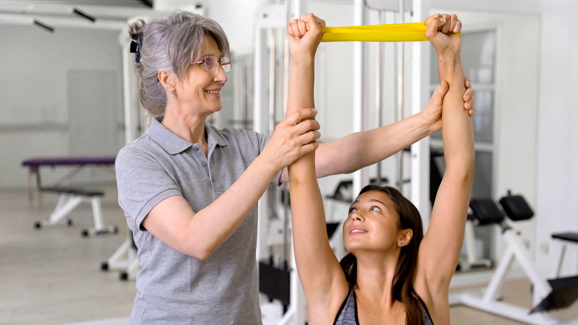 ATHERA Therapeut betreut Patientin an Trainingsgerät für gerätegestützte Krankengymnastik
