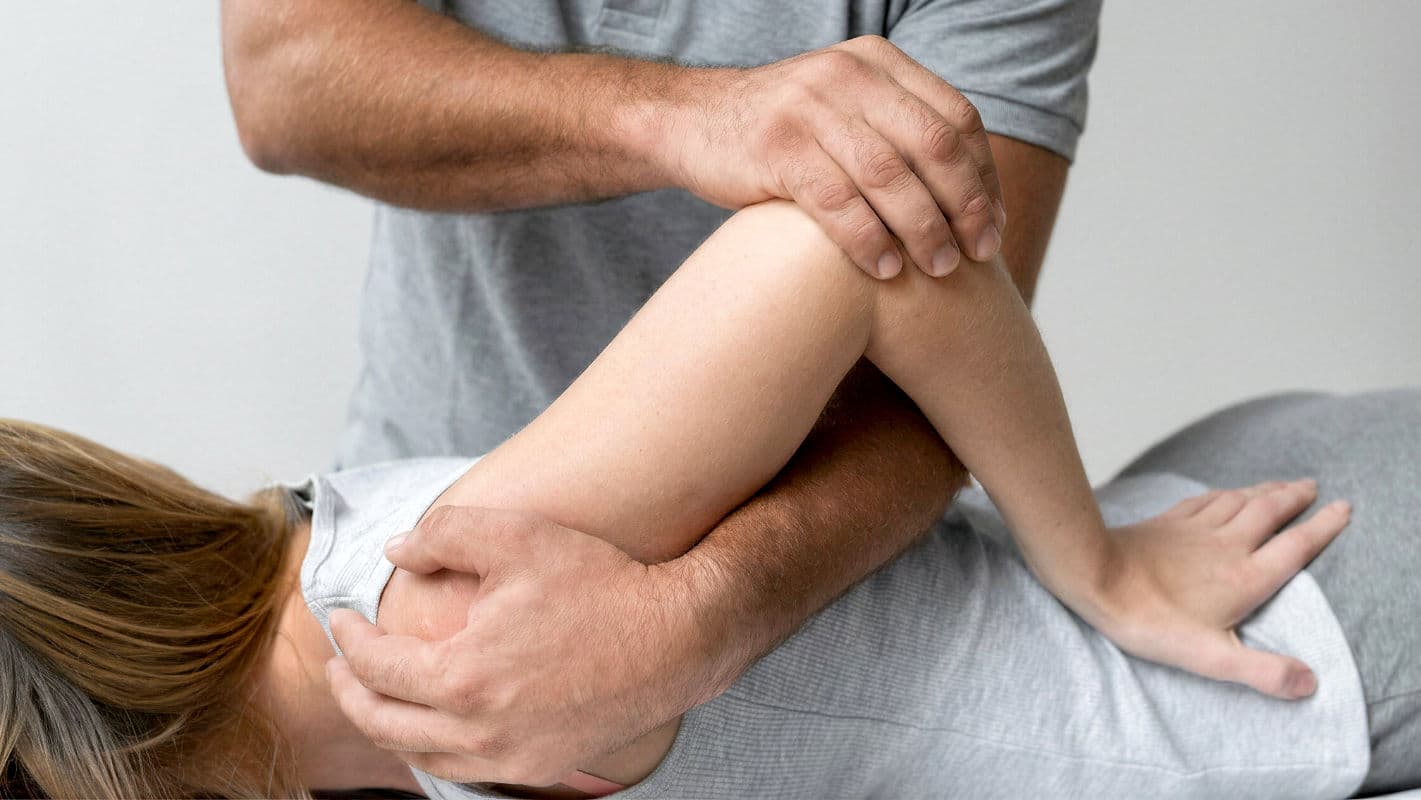 ATHERA Therapeutin behandelt Patientin an der Schulter mit manueller Therapie